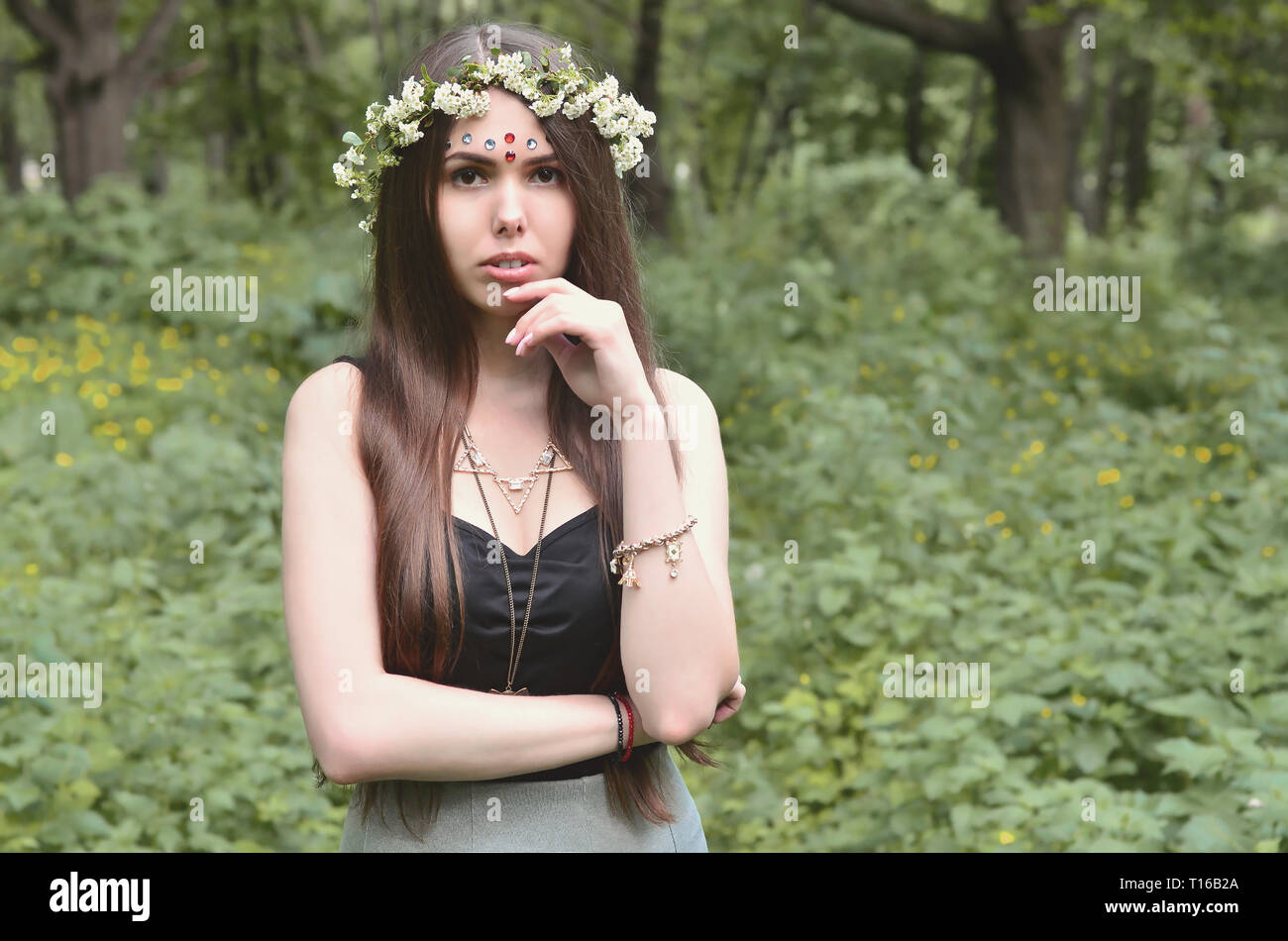 Portrait of an emotional young girl with a floral wreath on her head ...