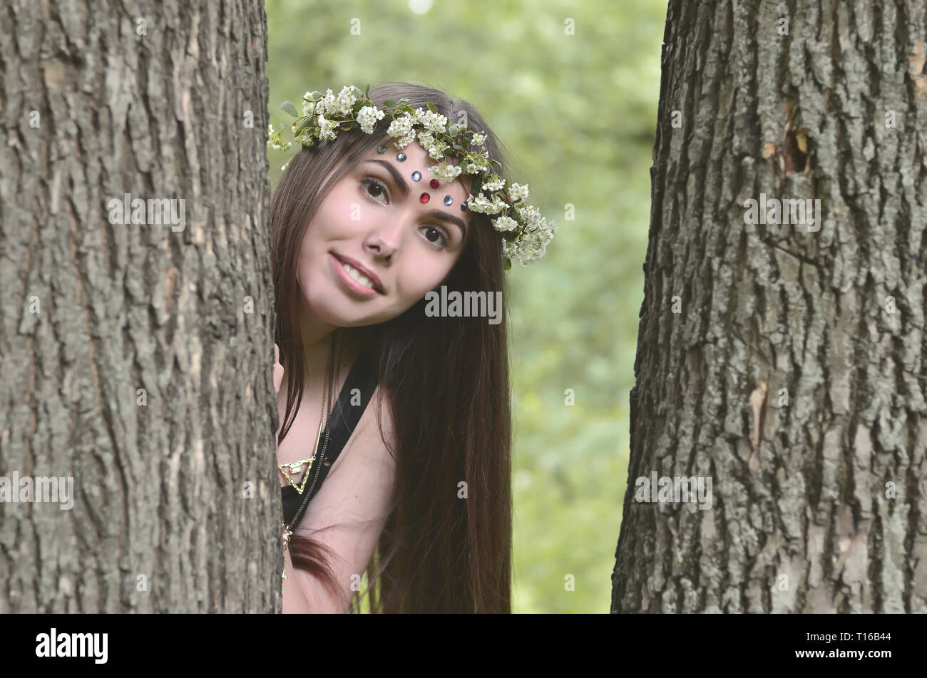 Portrait of an emotional young girl with a floral wreath on her head ...