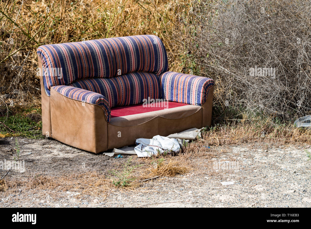 Sofa thrown away in natural area forest part illegal dumping trash