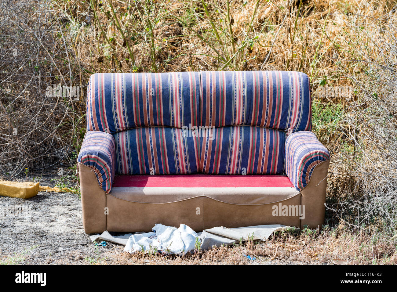 Sofa thrown away in natural area forest part illegal dumping trash
