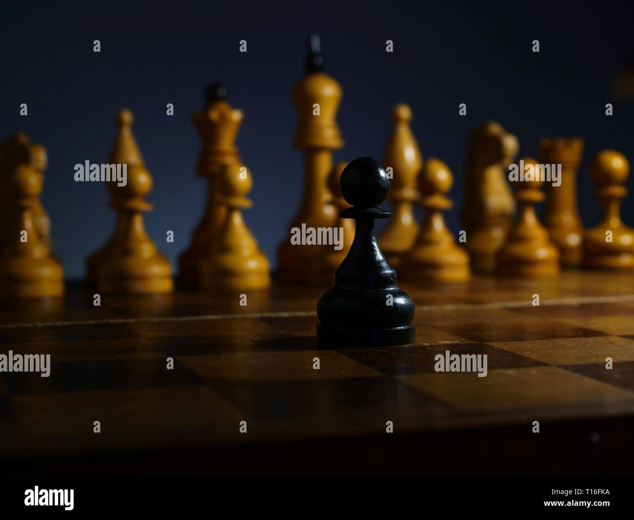 Brave ambitious businessman and challenge. Black wooden pawn and white chess. Stock Photo