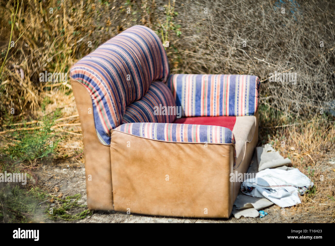 Sofa thrown away in natural area forest part illegal dumping trash
