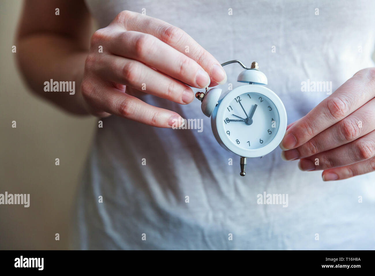 Female woman hands holding ringing twin bell vintage classic alarm
