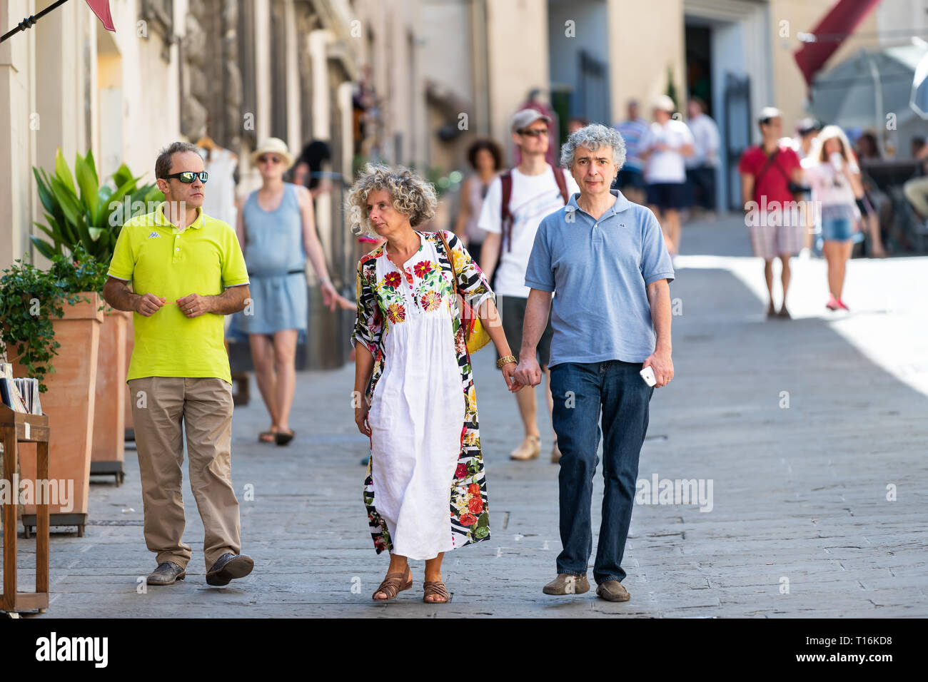 Montepulciano, Italy - August 28, 2018: Narrow alley street in small town village in Tuscany with couple people walking on summer day Stock Photo