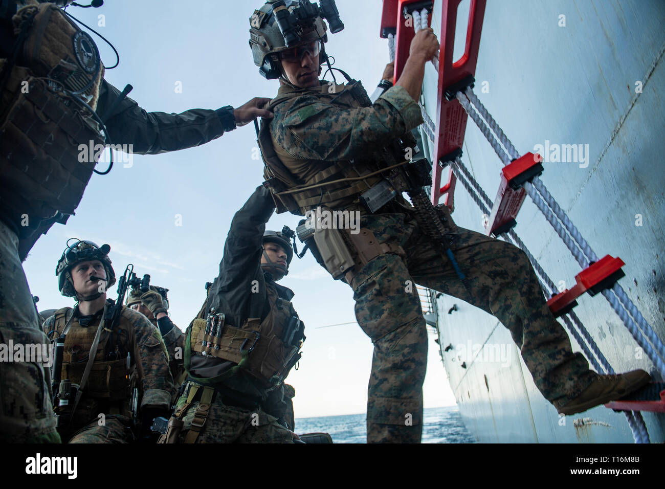 190322-N-HD110-0151  PACIFIC OCEAN (March 22, 2019) Sailors assigned to Assault Craft Unit (ACU) 1 assist a Marine assigned to Maritime Raid Force (MRF) down a pilot’s ladder and into a rigid-hull inflatable boat off the port side of Harpers Ferry-class amphibious dock landing ship USS Harpers Ferry (LSD 49) during a visit, board, search, and seizure exercise. Harpers Ferry is underway conducting routine operations as a part of USS Boxer Amphibious Ready Group (ARG) in the eastern Pacific Ocean. (U.S. Navy photo by Mass Communication Specialist 3rd Class Danielle A. Baker) Stock Photo