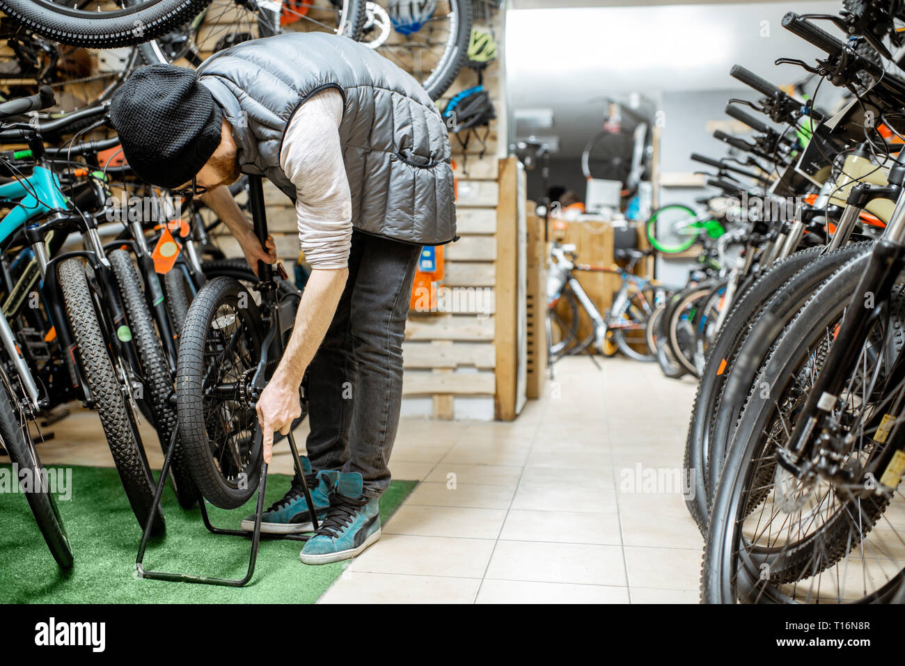 Stylish man making folding bicycle in the bicycle shop Stock Photo