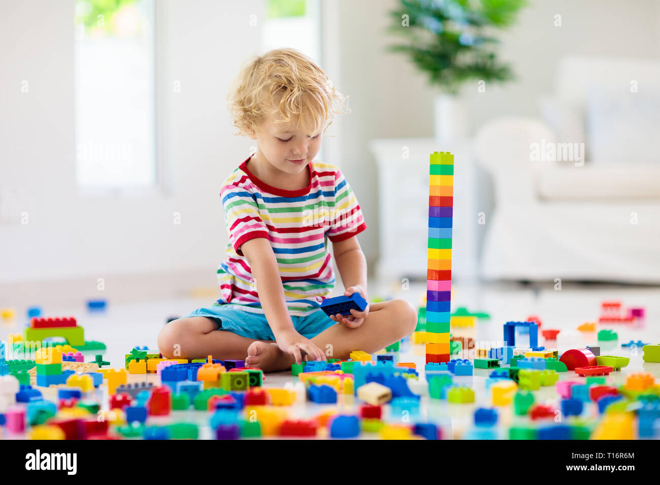 Child playing with colorful toy blocks. Little boy building tower at ...