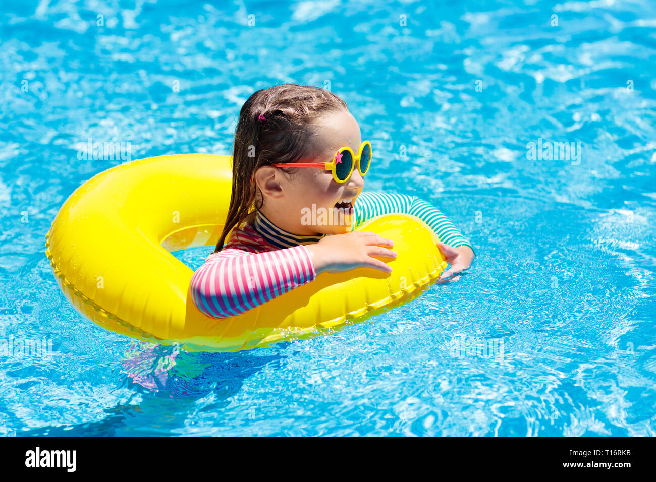 Child with sunglasses in swimming pool. Little girl on inflatable ring. Kid  with colorful float. Kids learn to swim and dive in outdoor pool of tropic  Stock Photo - Alamy