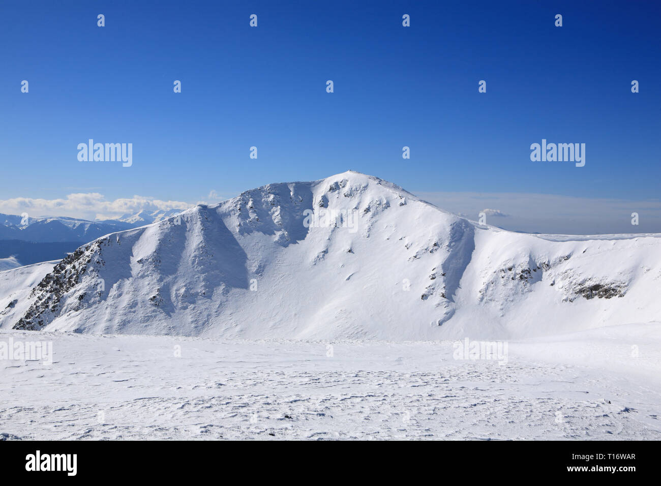 The mountains are covered with snow under a bright blue sky Stock Photo ...