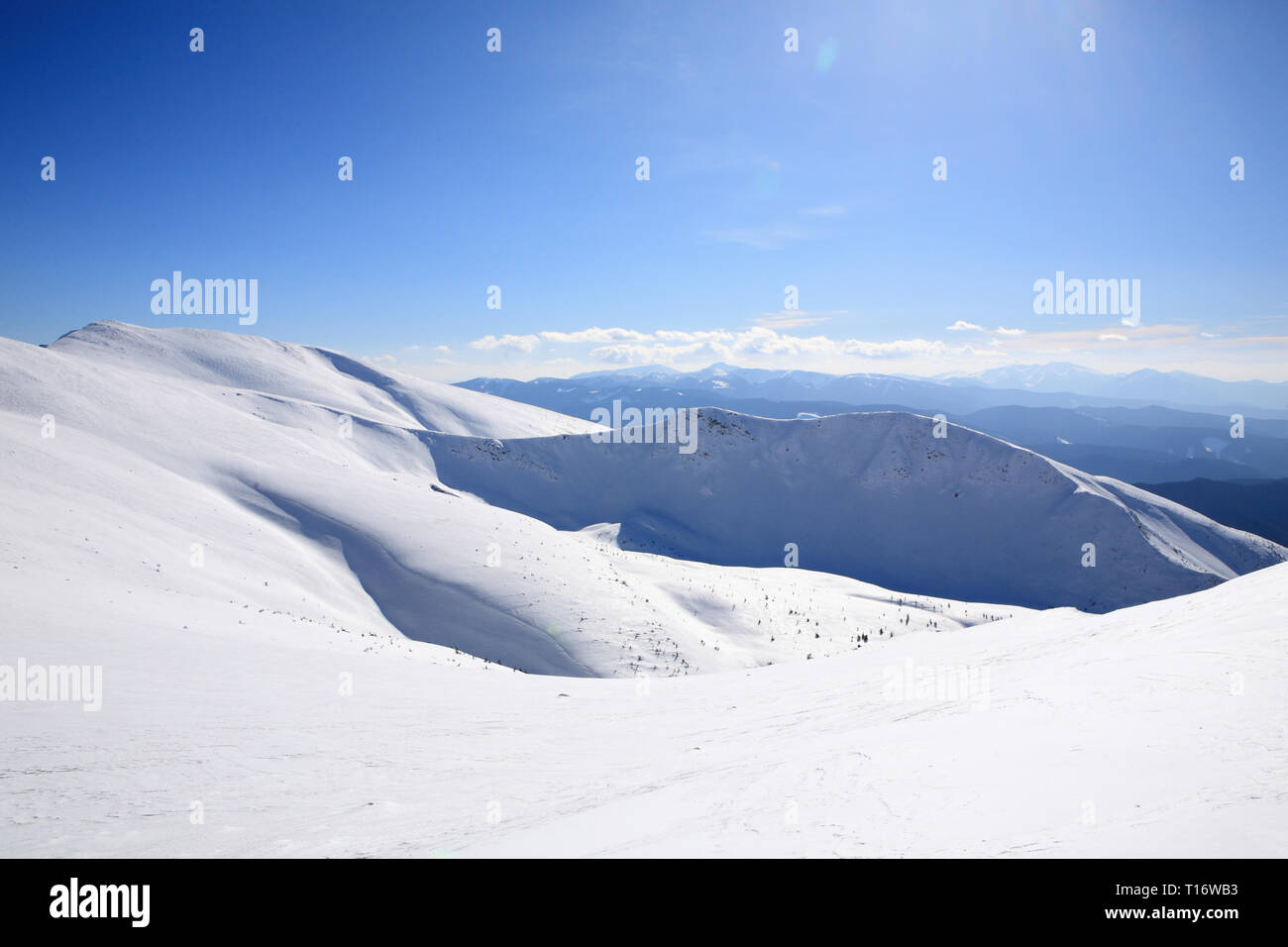 The mountains are covered with snow under a bright blue sky Stock Photo ...