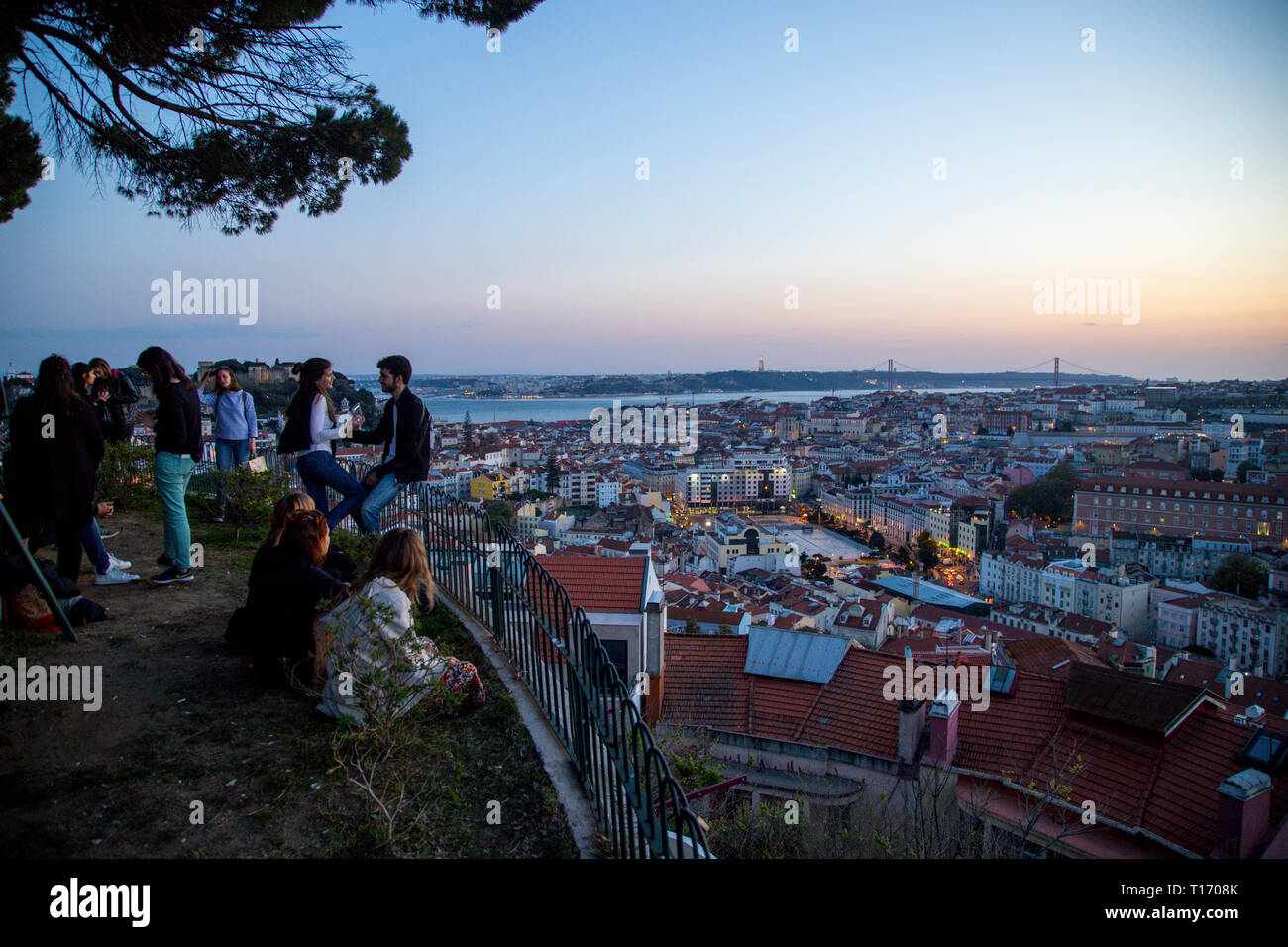 View of Lisbon from a hill at the sunset, with a group of young people Stock Photo