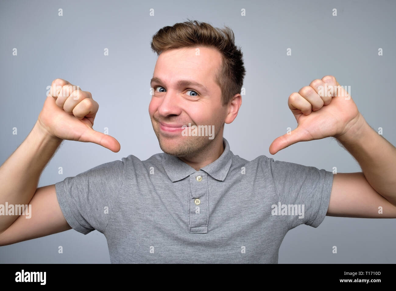 proud young man looks forward pointing at himself Stock Photo
