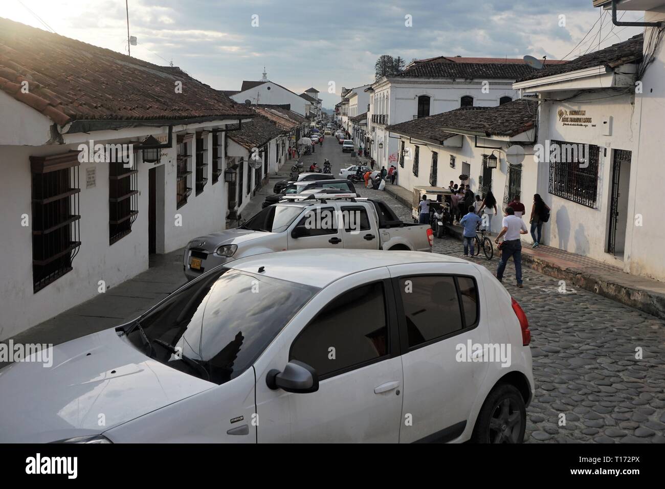 View down a Street full of Cars and Whitewashed Houses in Popayan, Colombia Stock Photo