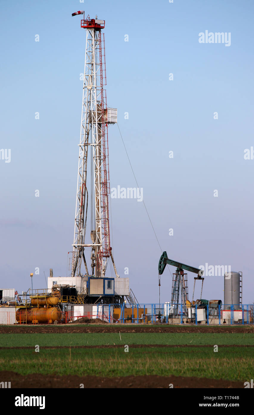 Oil and gas drilling rig and pump jack in oilfield Stock Photo - Alamy