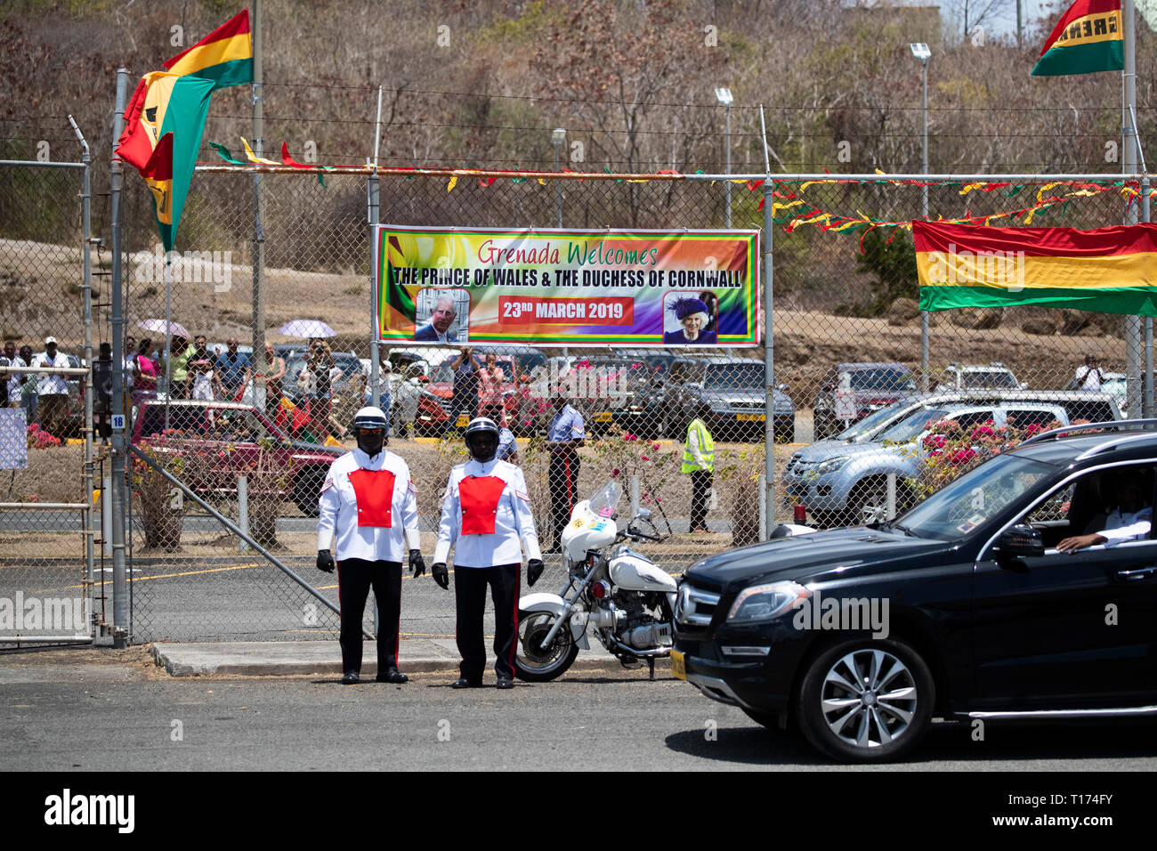 Banner and flags for the Prince of Wales and the Duchess of Cornwall as they arrive at Maurice Bishop International Airport on a one day visit to the Caribbean island of Grenada. Stock Photo