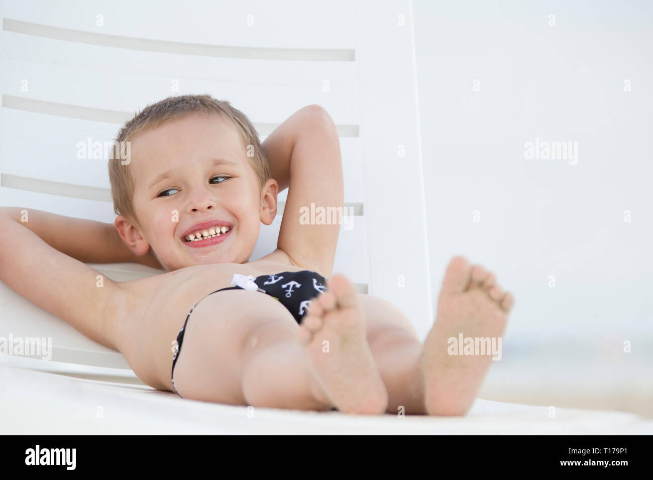 A Child In A Lounge Chair By The Sea Little Boy Resting On The