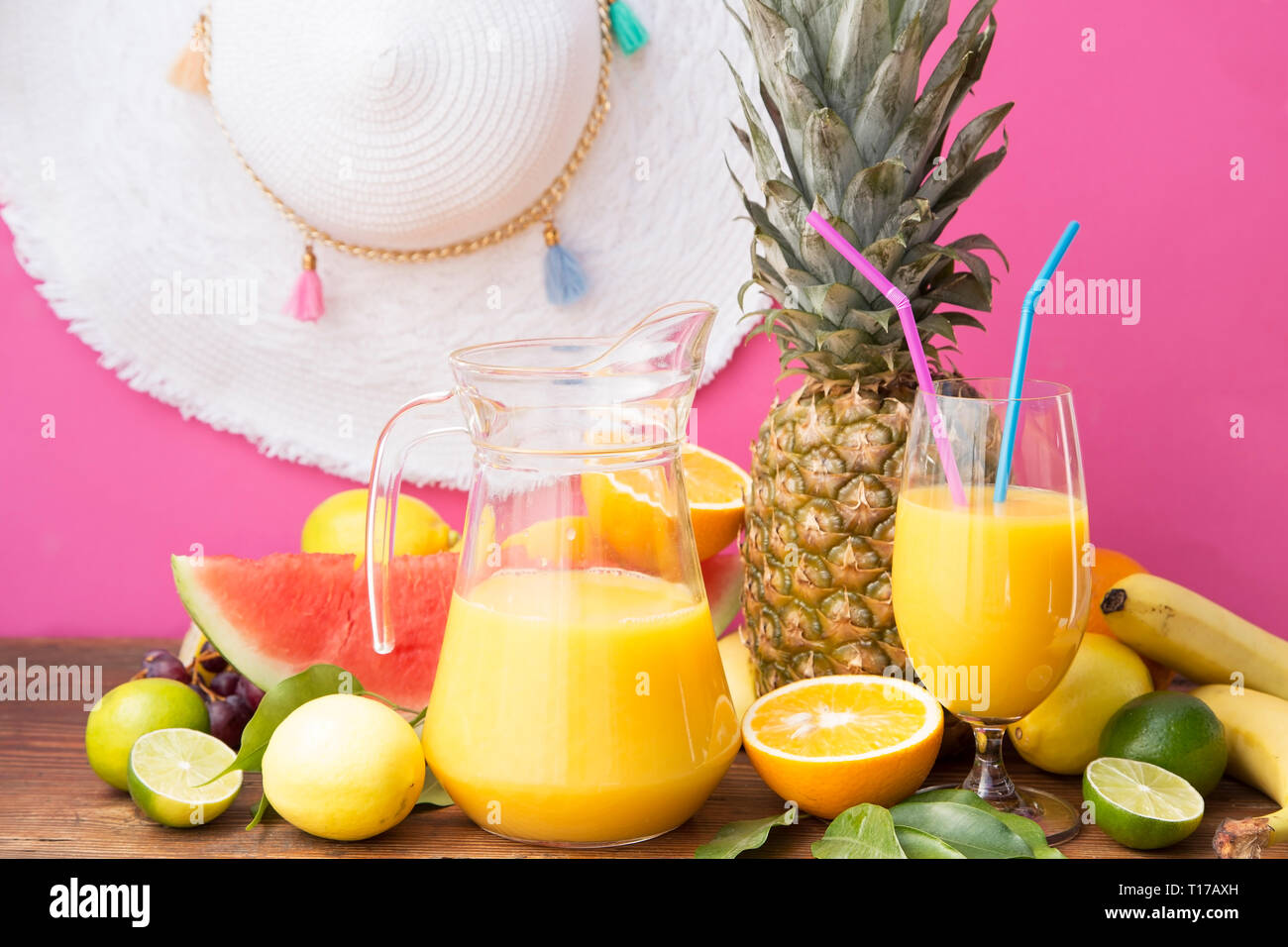 Tropical fruits with juice on wooden table Stock Photo - Alamy