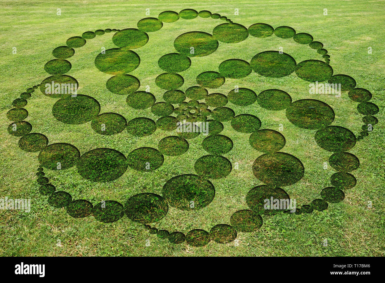 Concentric circles spirals encrypted symbols fake crop circle in the meadow Stock Photo