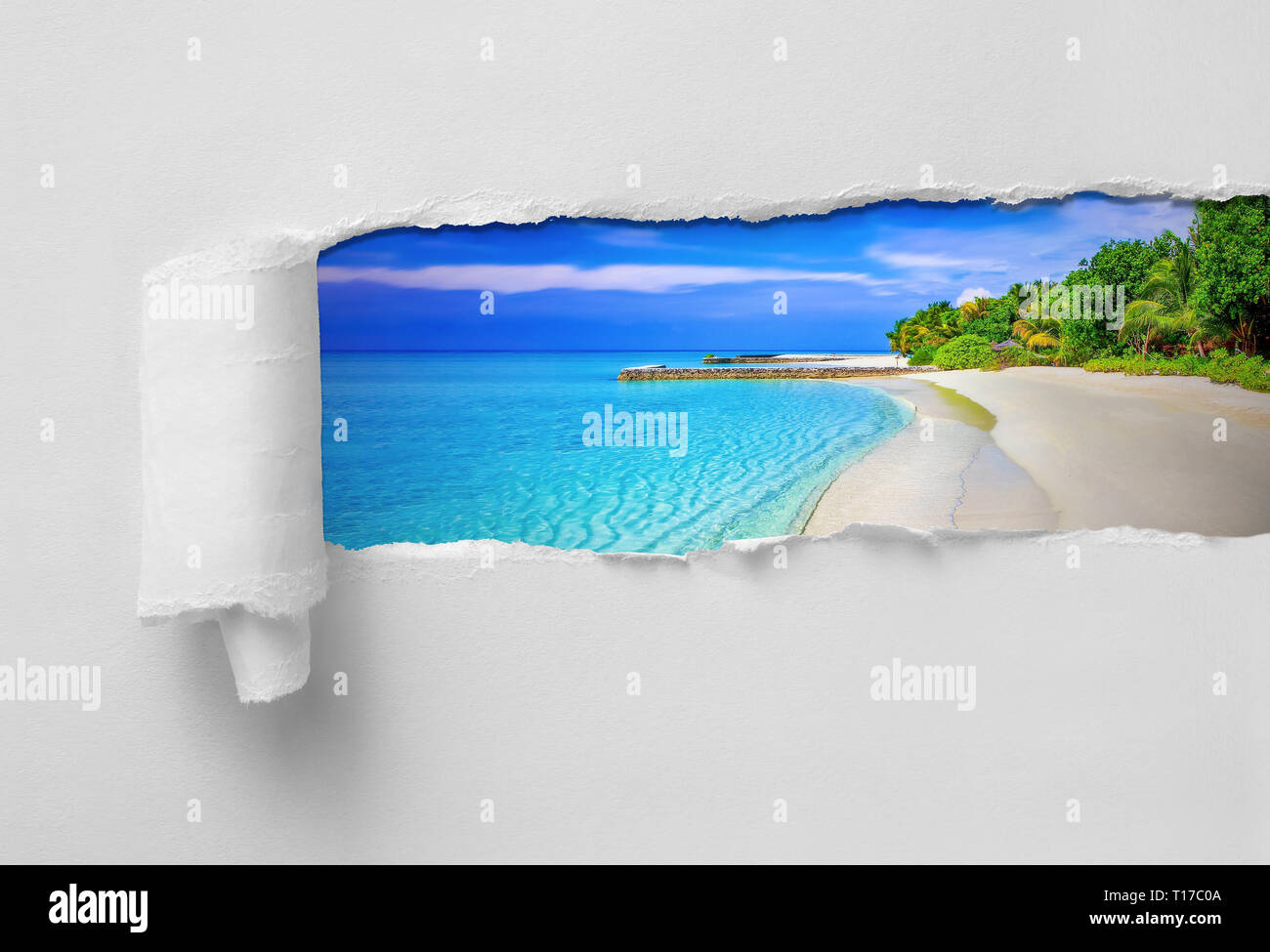 Paper Ripped revealing paradisiac tropical sea and beach vacation destination Stock Photo