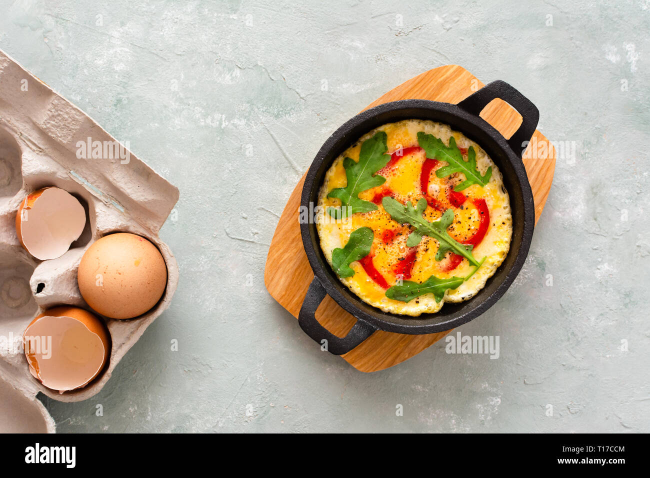 Omelette with fresh pepper and arugula. Frittata in frying pan Stock