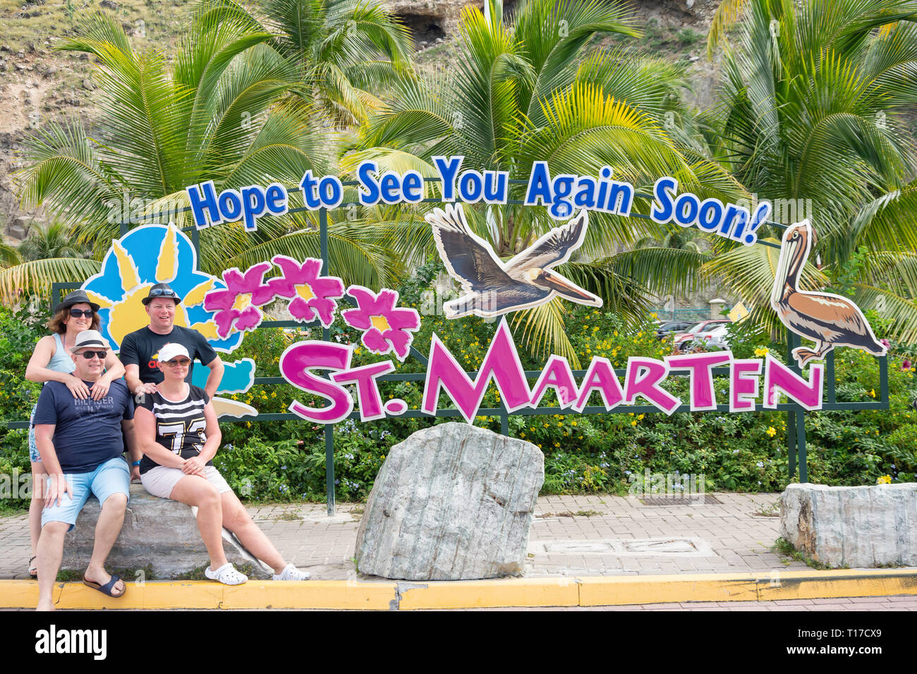 Group posing in front of St Maarten farewell sign at Cruise Terminal, Philipsburg, St Maarten, Saint Martin, Lesser Antilles, Caribbean Stock Photo