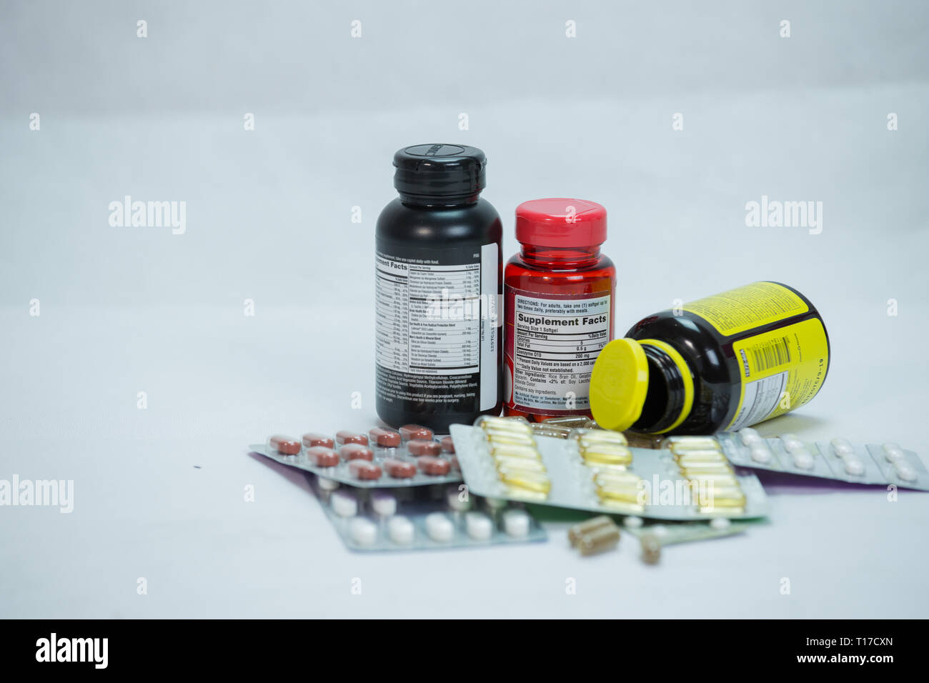 Multiple Drug bottle with capsules poured out with white background Stock Photo