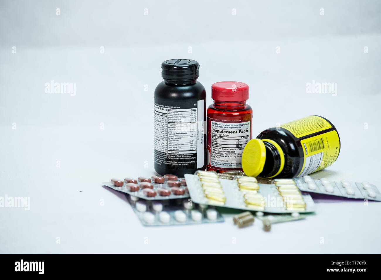 Multiple Drug bottle with capsules poured out with white background Stock Photo