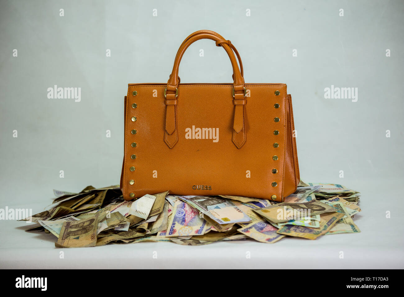 Naira cash heap with womens bag - concept of high fashion cost on white background Stock Photo