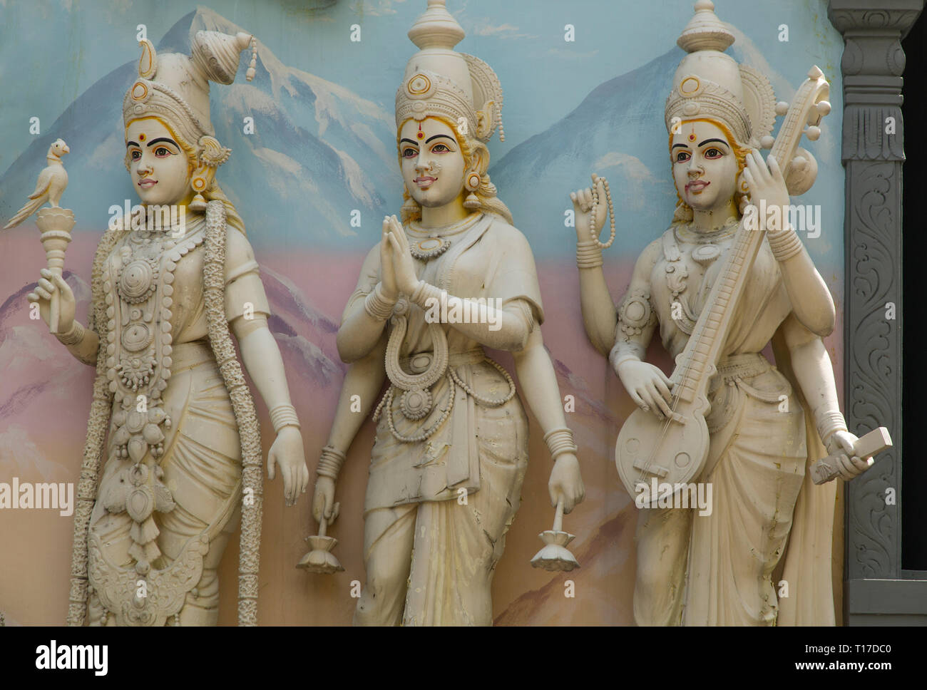 Three female sculptures on a facade at the exterior of the Hindu temple Sri Senpaga Vinayagar , Singapore Stock Photo