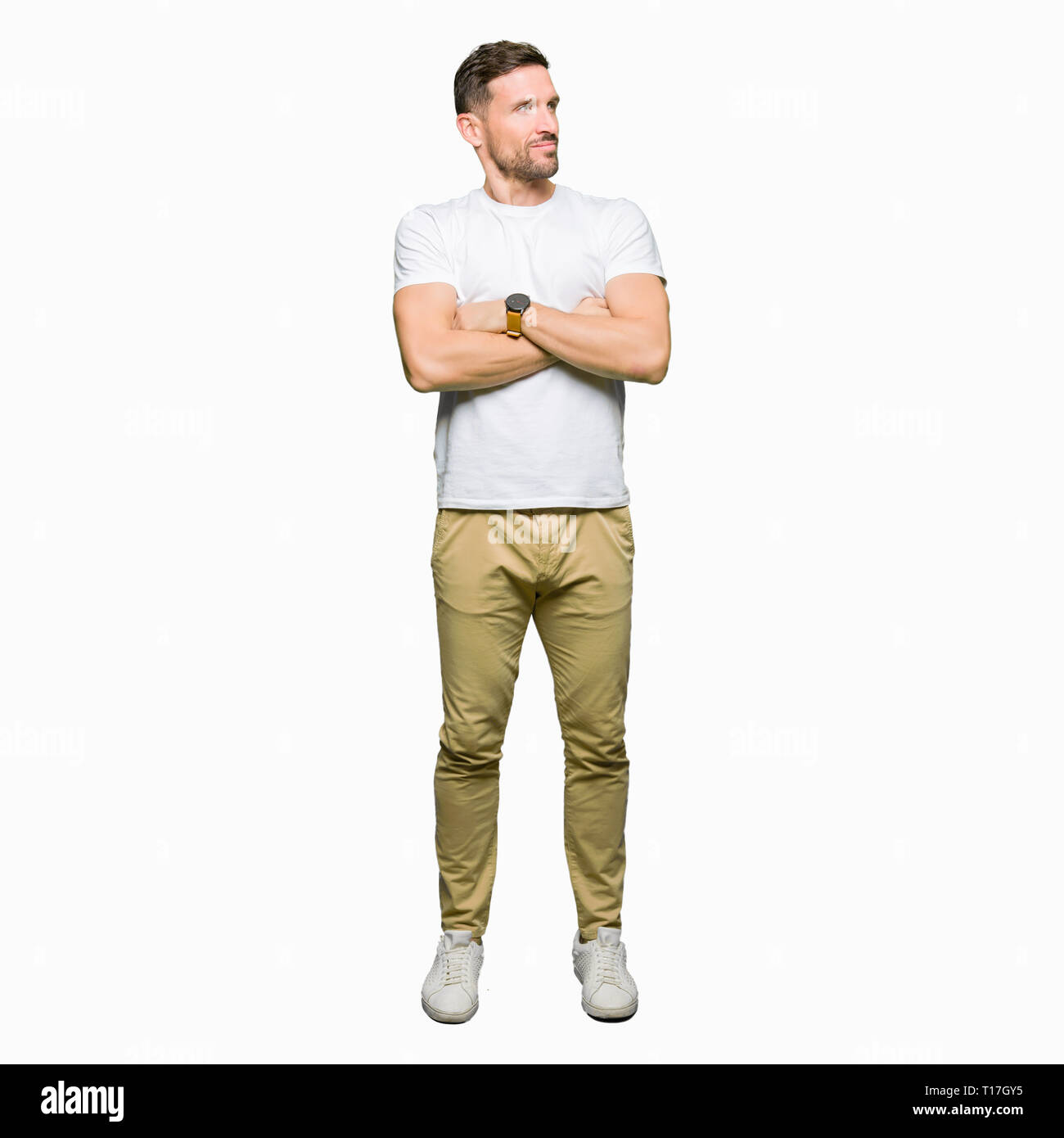 Handsome man wearing casual white t-shirt smiling looking to the side ...