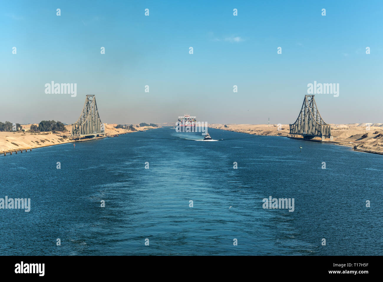 Ismailia, Egypt - November 5, 2017: El Ferdan Railway Bridge and container vessel ship MSC Maya passing Suez Canal in Egypt. Tugboat accompanies the s Stock Photo