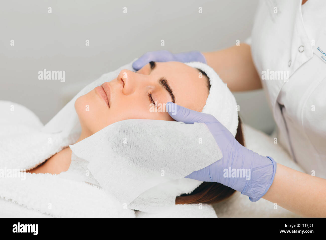woman receiving facial treatment at beauty salon. Exfoliation Stock Photo