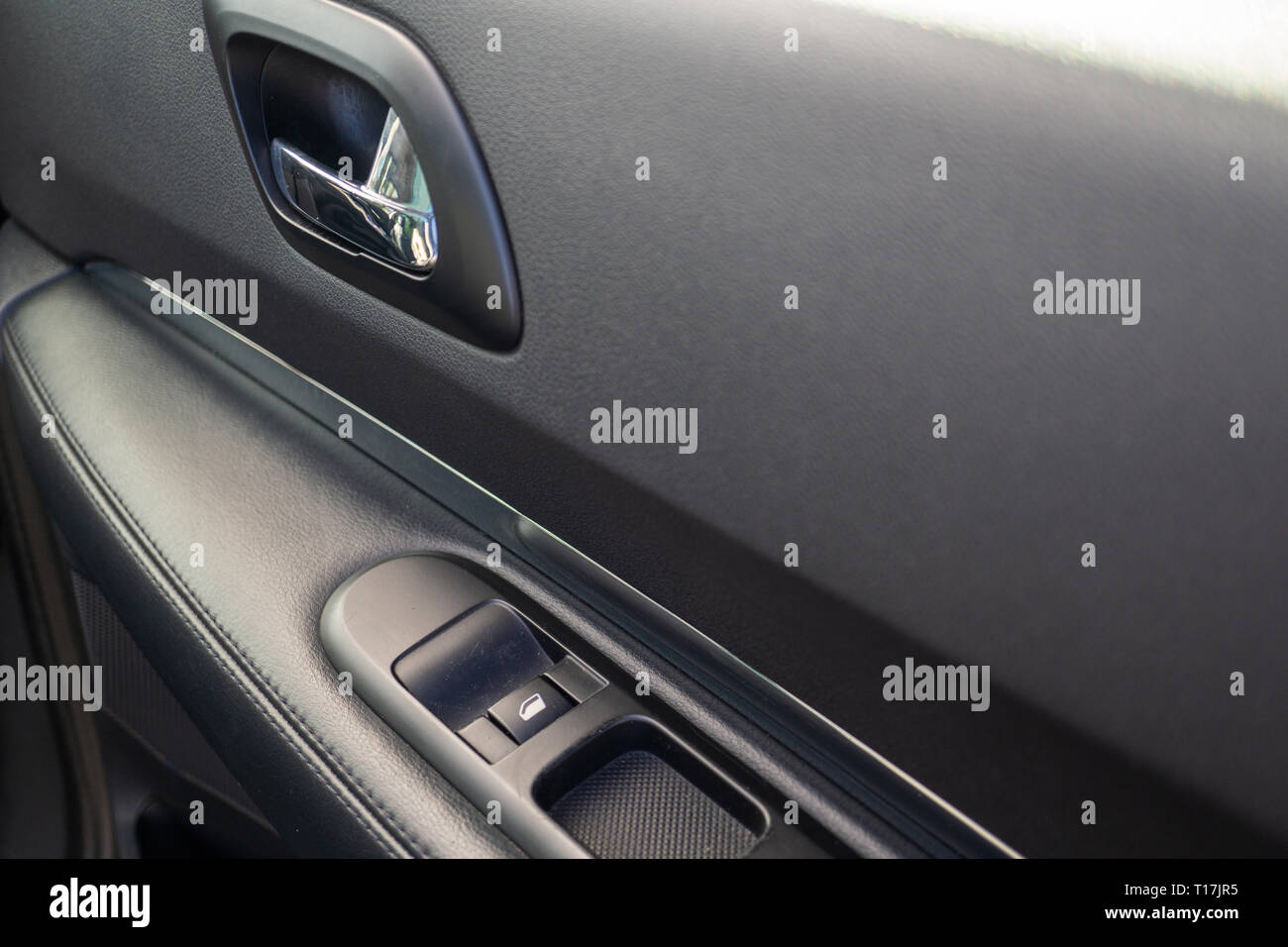 Car interior details of door handle with windows controls. Car window