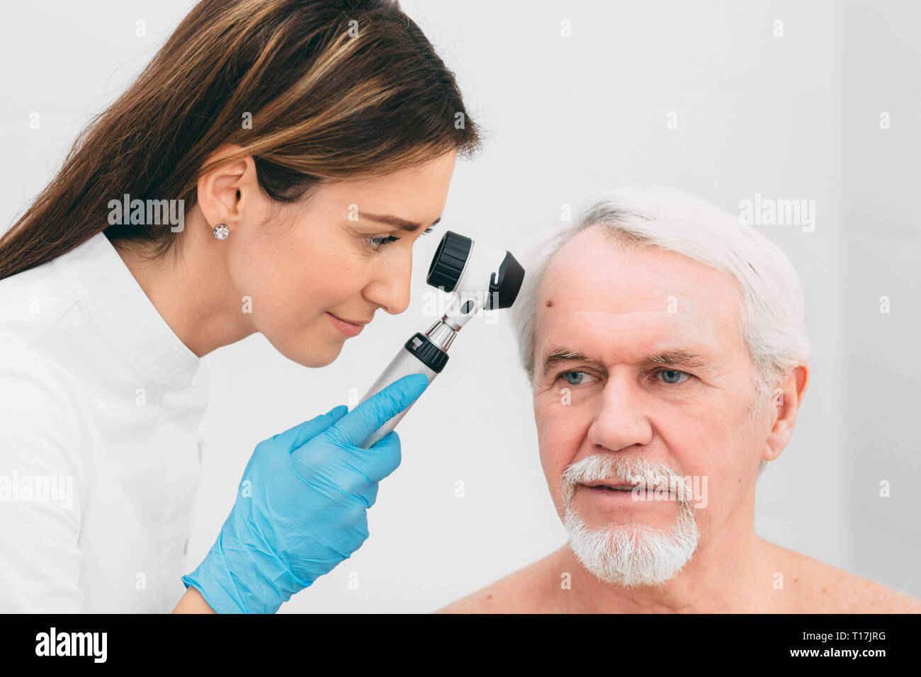 dermatologist Inspecting patient skin moles at clinic Stock Photo