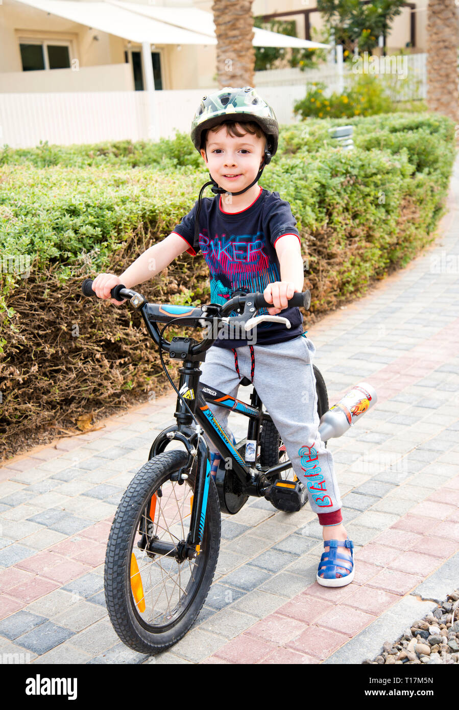 young boy sitting on bike resting looking towards camera getting ready
