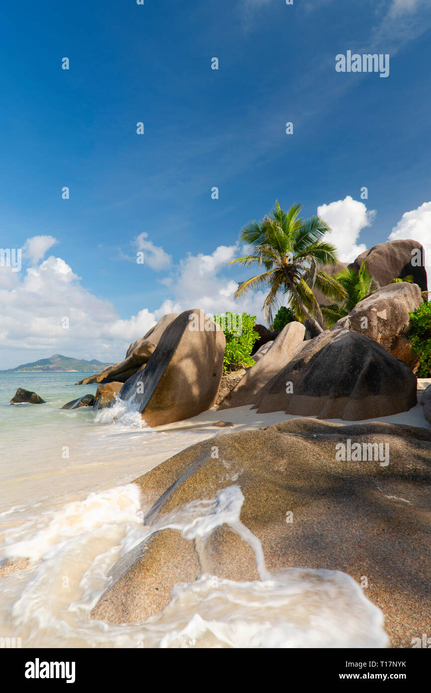 Surf on distinctive large granite boulders on L’Anse Source d’Argent, La Digue, the Seychelles. Stock Photo