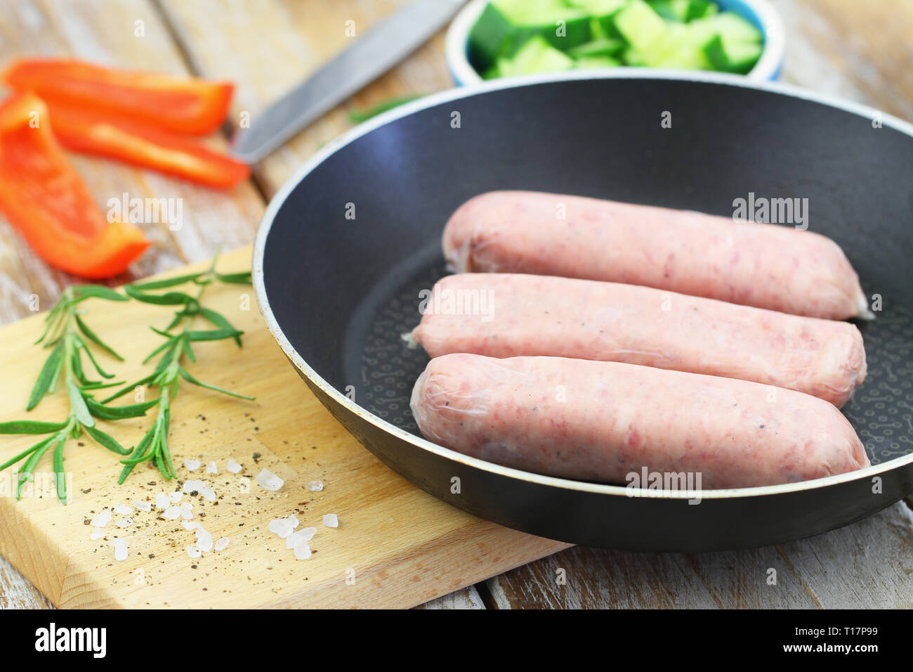 Raw British pork sausages in frying pan Stock Photo