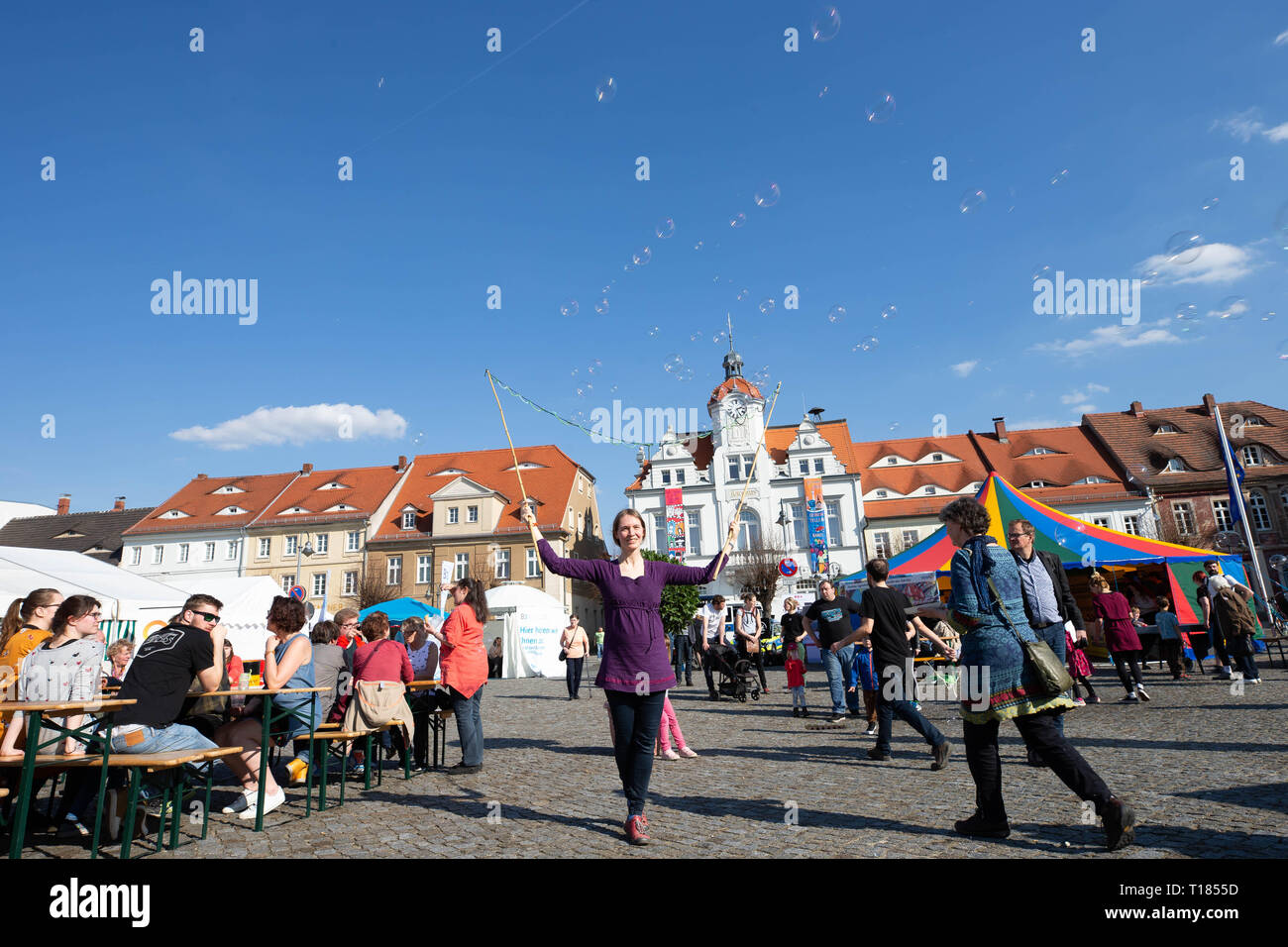 Ostritz, Germany. 23rd Mar, 2019. Tabea Scheinflug (center) from Görlitz created soap bubbles on the market square. The city of Ostritz wants to react to the neo-Nazi festival 'Skinheads Back to the Roots' with a peace festival. Credit: Daniel Schäfer/dpa/Alamy Live News Stock Photo
