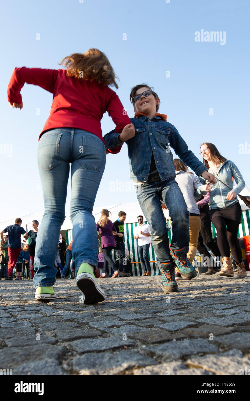 Ostritz, Germany. 23rd Mar, 2019. A mother dances a peace dance with her son on the market square. The city of Ostritz wants to react to the neo-Nazi festival 'Skinheads Back to the Roots' with a peace festival. Credit: Daniel Schäfer/dpa/Alamy Live News Stock Photo