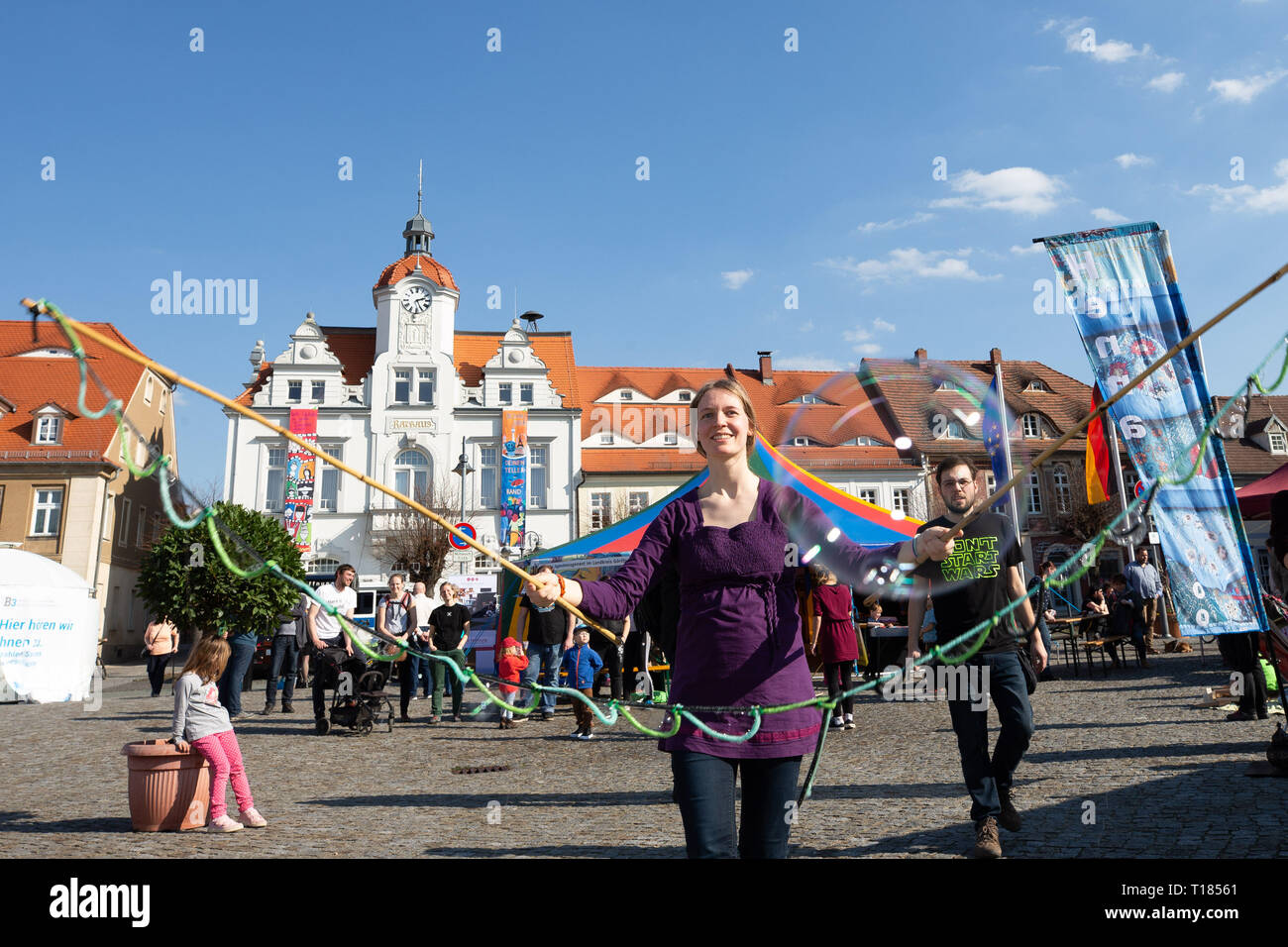 Ostritz, Germany. 23rd Mar, 2019. Tabea Scheinflug (center) from Görlitz created soap bubbles on the market square. The city of Ostritz wants to react to the neo-Nazi festival 'Skinheads Back to the Roots' with a peace festival. Credit: Daniel Schäfer/dpa/Alamy Live News Stock Photo