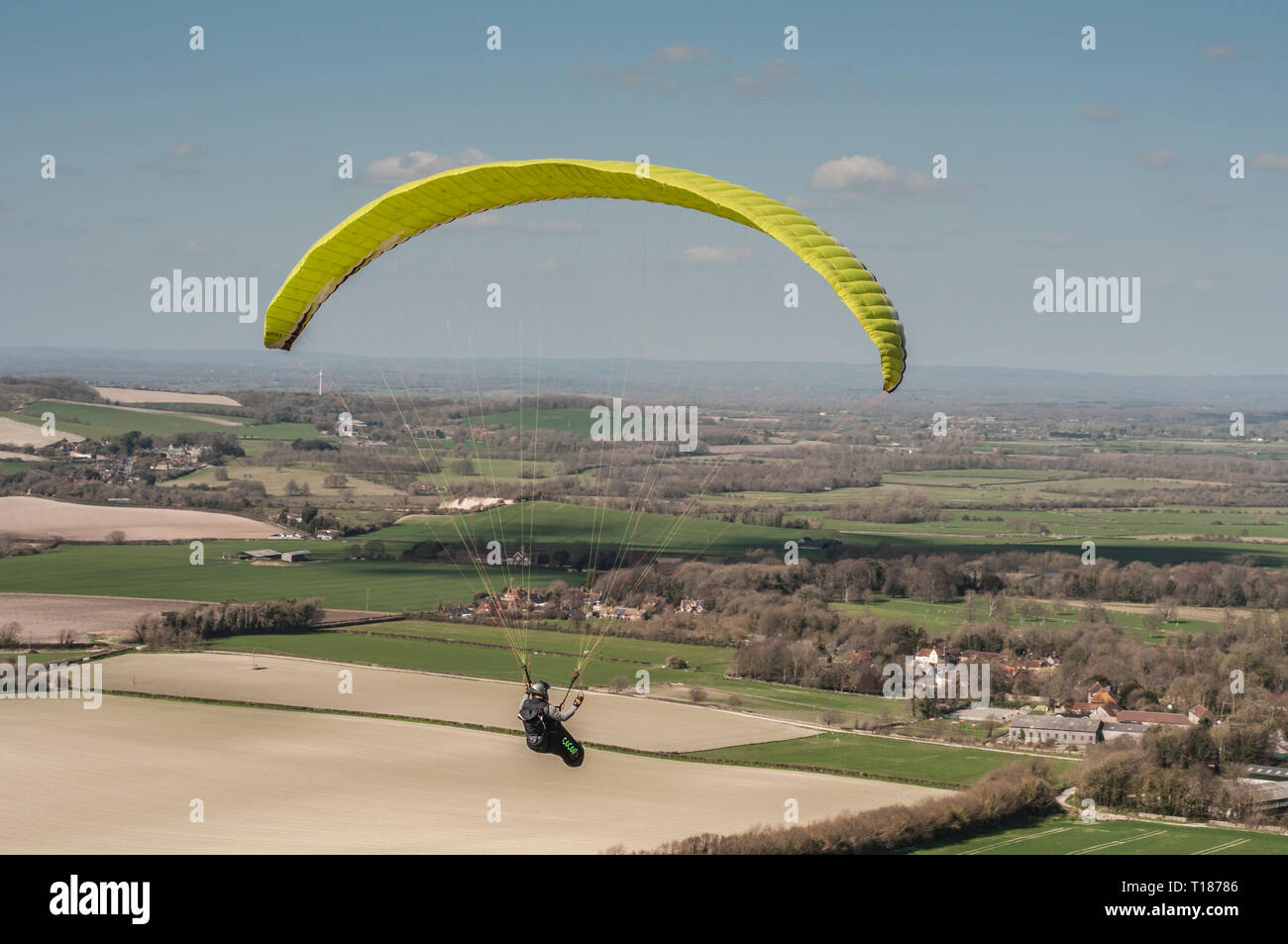 Firle, Lewes, East Sussex, UK. 24th Mar 2019. A glorious afternoon in the South Downs. Paraglider over the countryside. Stock Photo