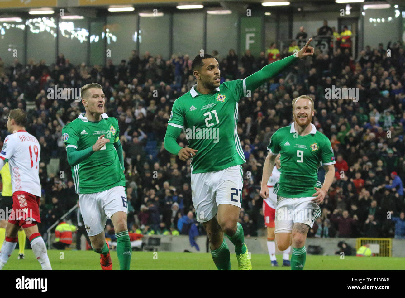National Football Stadium at Windsor Park, Belfast, Northern Ireland. 24  March 2019. UEFA EURO 2020 Qualifier- Northern Ireland v Belarus. Action from tonight's game. Josh Magennis  (21) celebrates his winner for Northern Ireland with Steven Davis (8) and Liam Boyce (9). Credit: David Hunter/Alamy Live News. Stock Photo