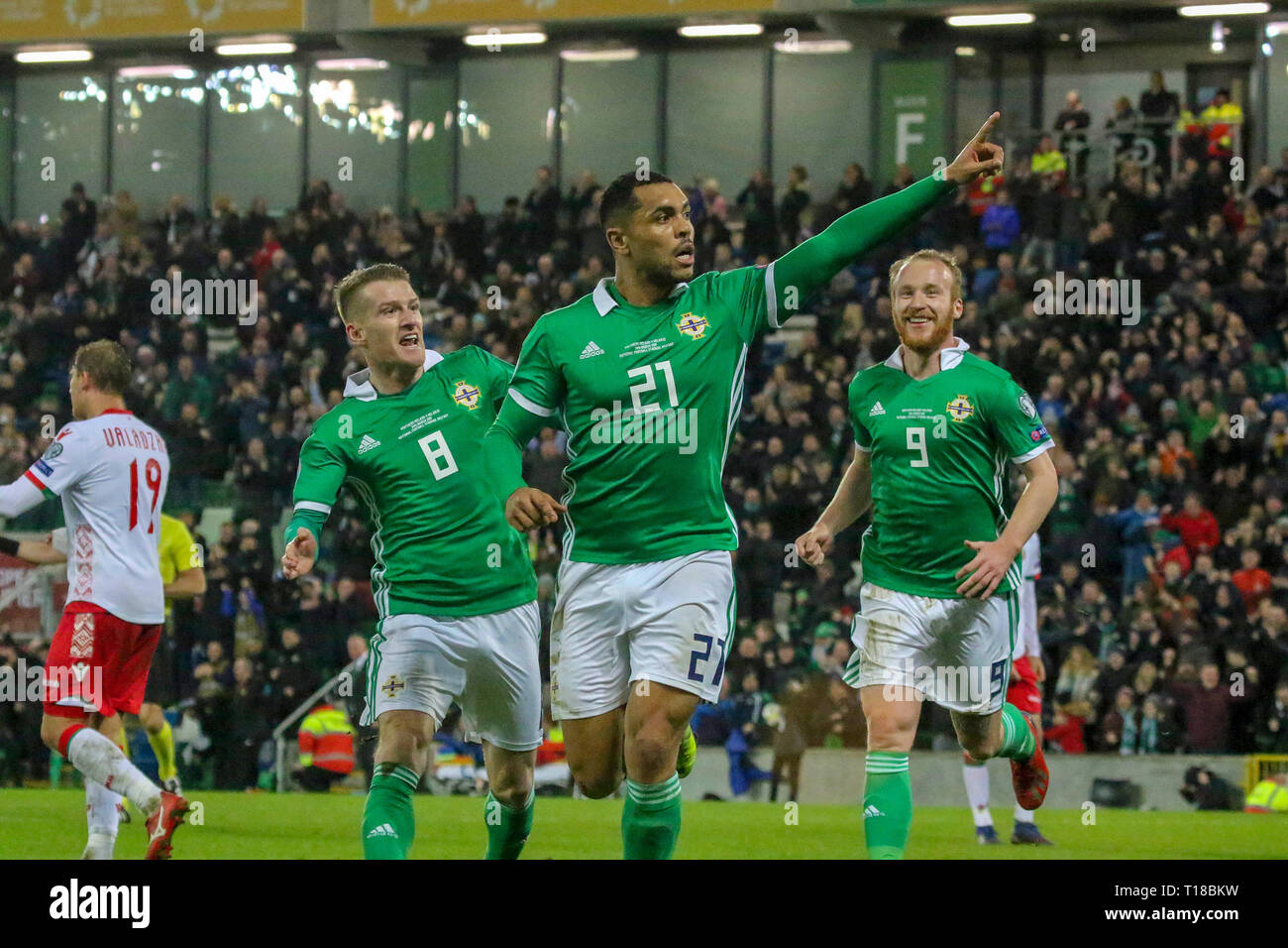 National Football Stadium at Windsor Park, Belfast, Northern Ireland. 24  March 2019. UEFA EURO 2020 Qualifier- Northern Ireland v Belarus. Action from tonight's game. Josh Magennis  (21) celebrates his winner for Northern Ireland with Steven Davis (8) and Liam Boyce (9).  Credit: David Hunter/Alamy Live News. Stock Photo