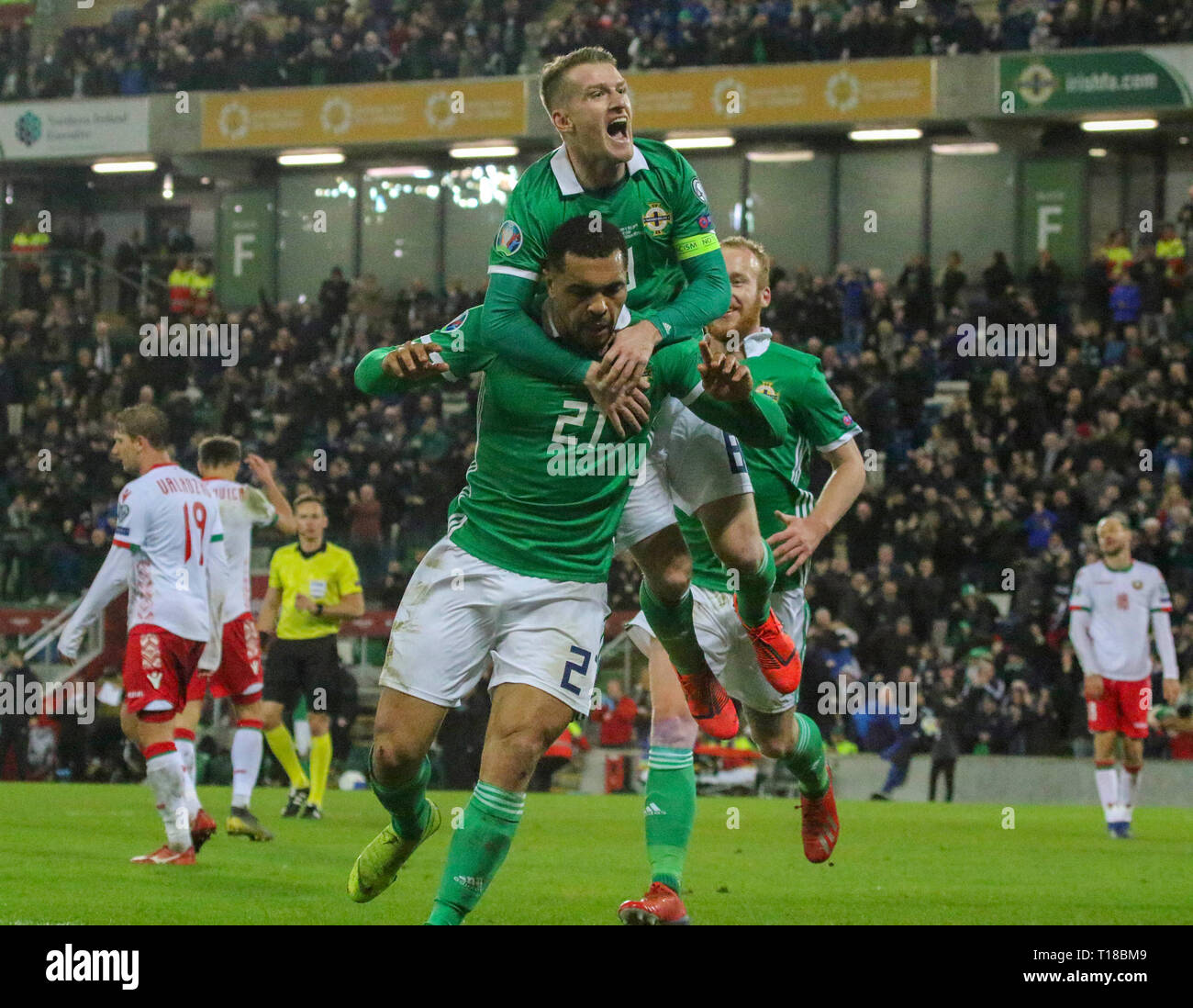 National Football Stadium at Windsor Park, Belfast, Northern Ireland. 24 March 2019. UEFA EURO 2020 Qualifier- Northern Ireland v Belarus. Action from tonight's game. Josh Magennis  (21) celebrates his winner for Northern Ireland with Steven Davis (8) and Liam Boyce (9). Credit: David Hunter/Alamy Live News. Stock Photo