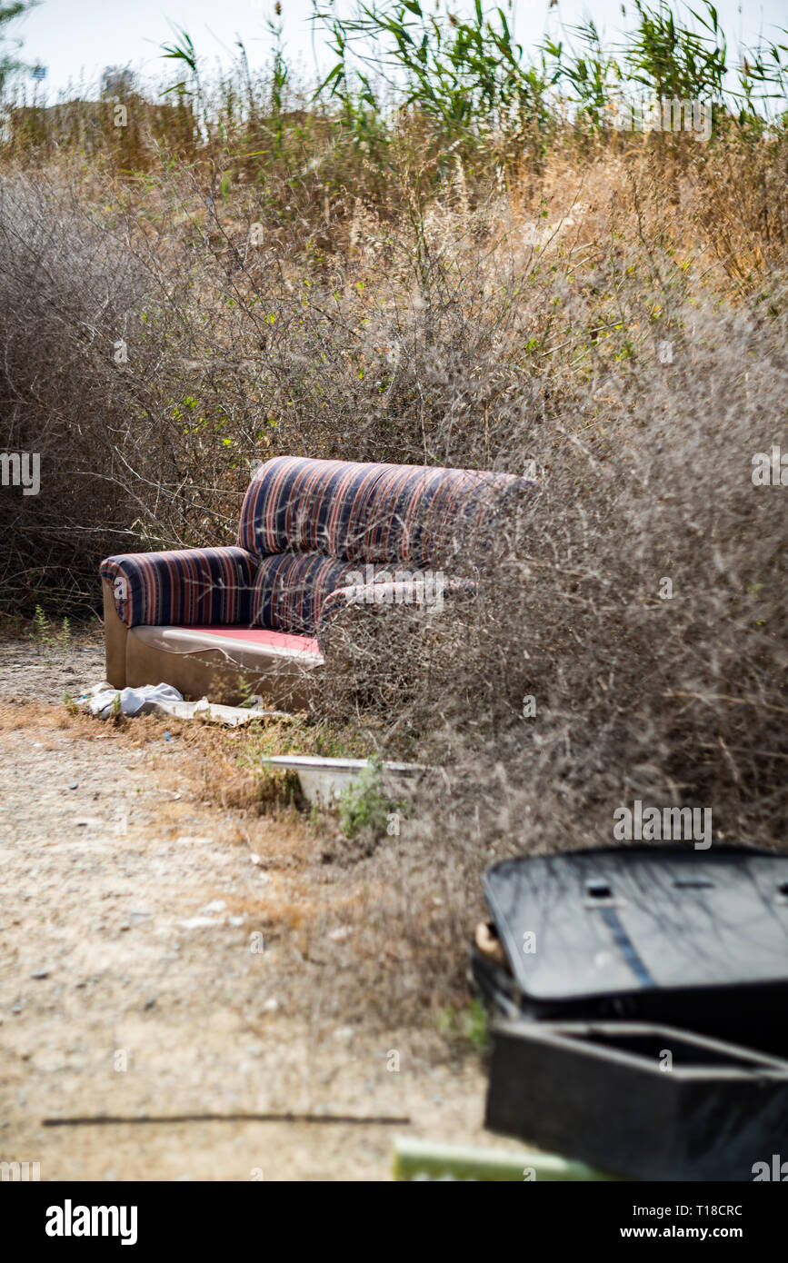 Sofa thrown away in natural area forest part illegal dumping trash