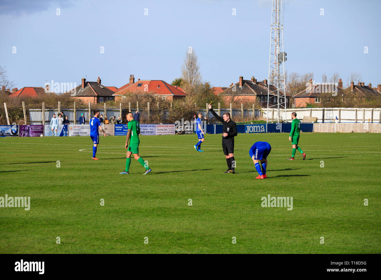 Local amateur football match between Billingham Town and Easington Colliery in north east England,UK. Referee shows yellow card to defender. Stock Photo