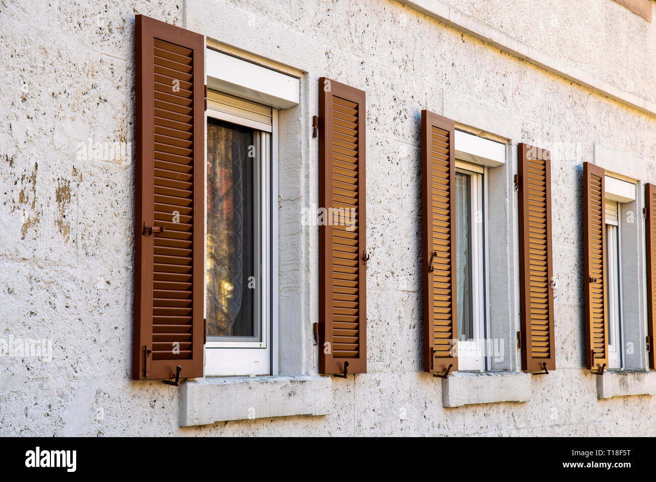 House facade with two windows with old wooden shutters with slats Stock ...