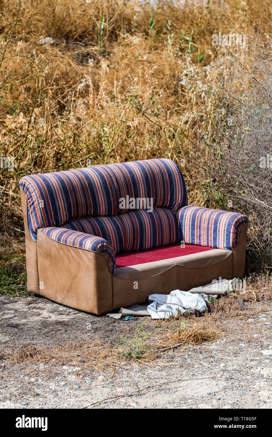 Sofa thrown away in natural area forest part illegal dumping trash