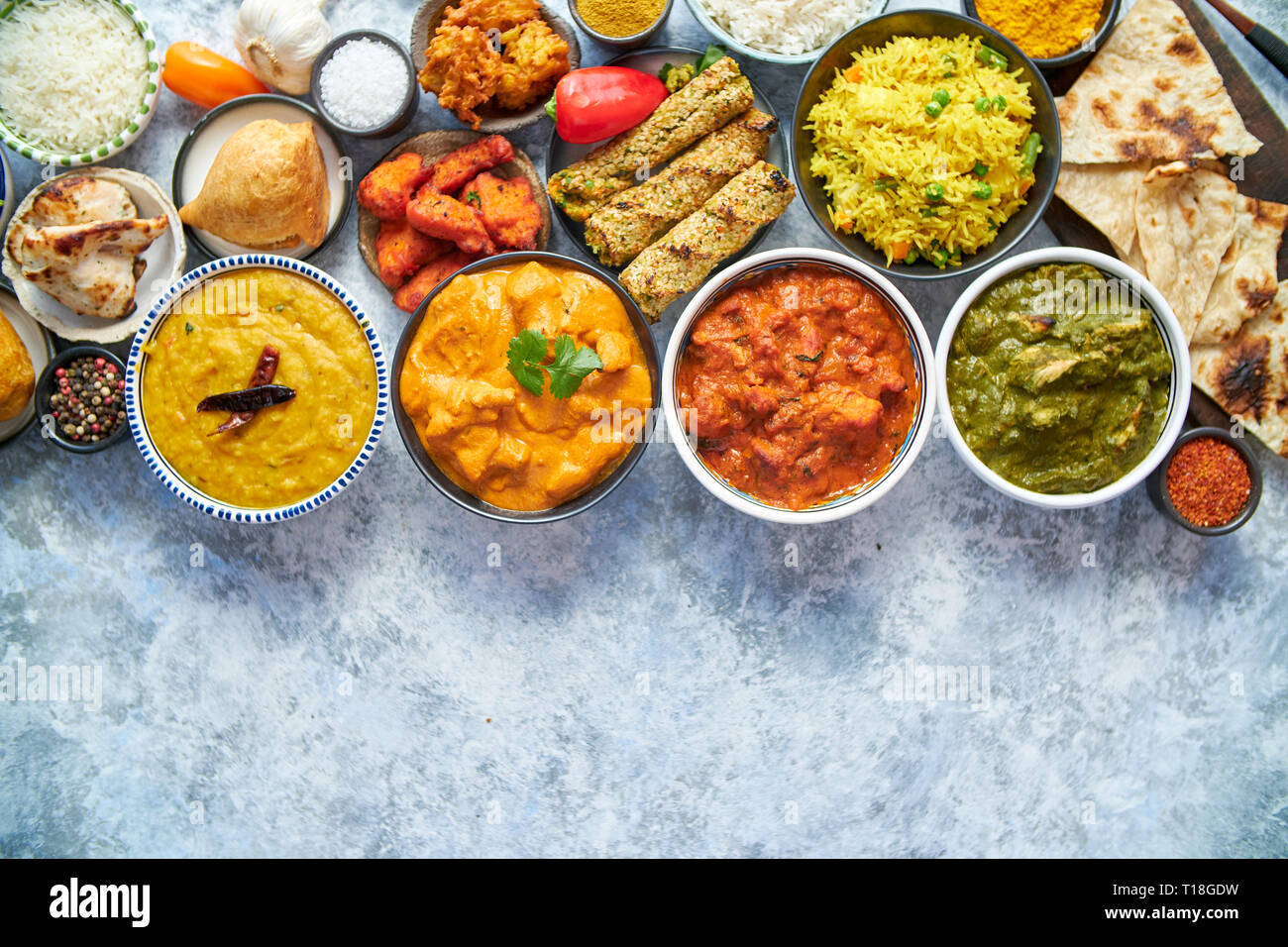 Composition of Indian cuisine in ceramic bowls on stone table. Tikka