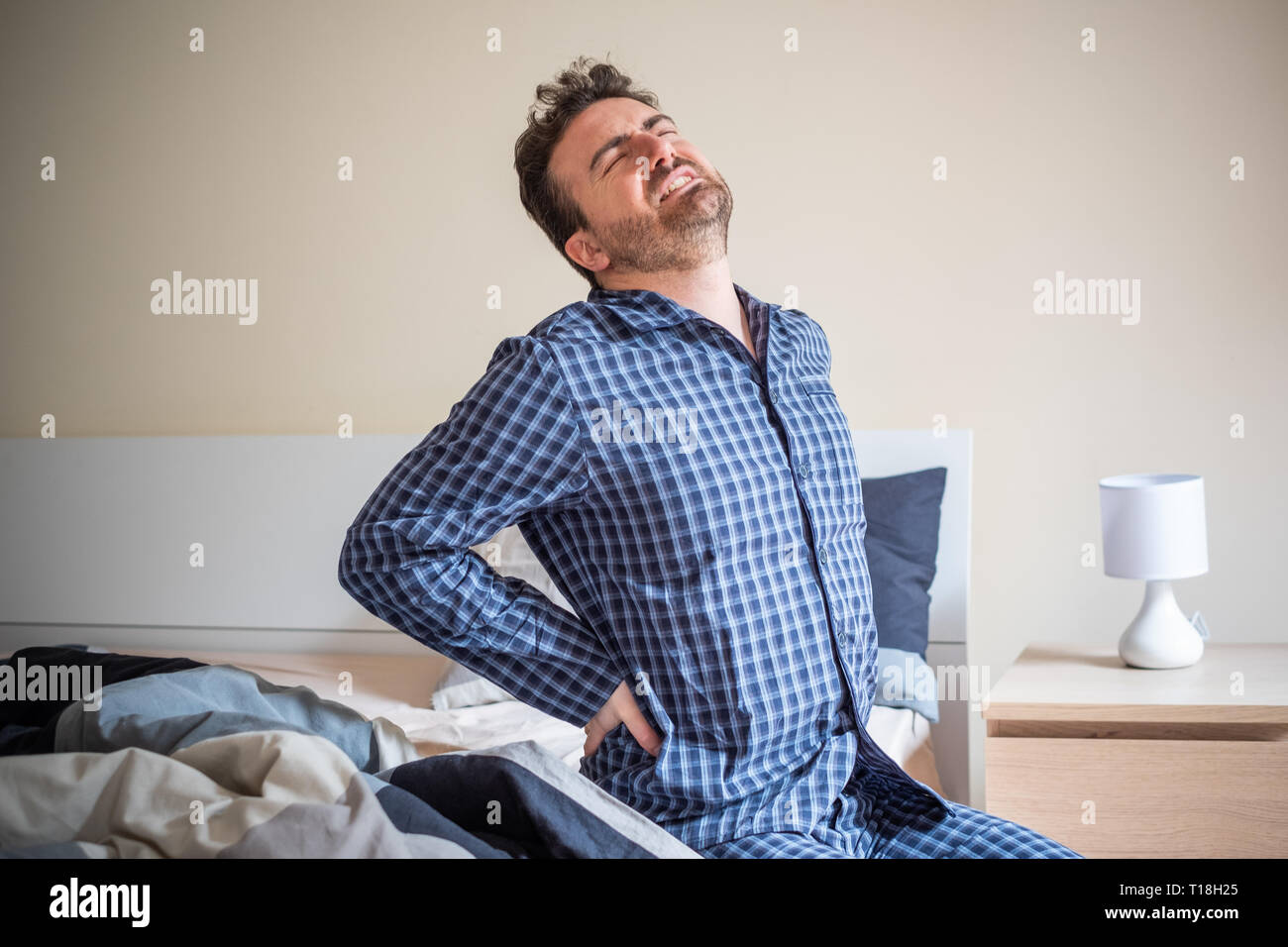 Man waking up and feeling morning back pain Stock Photo Alamy